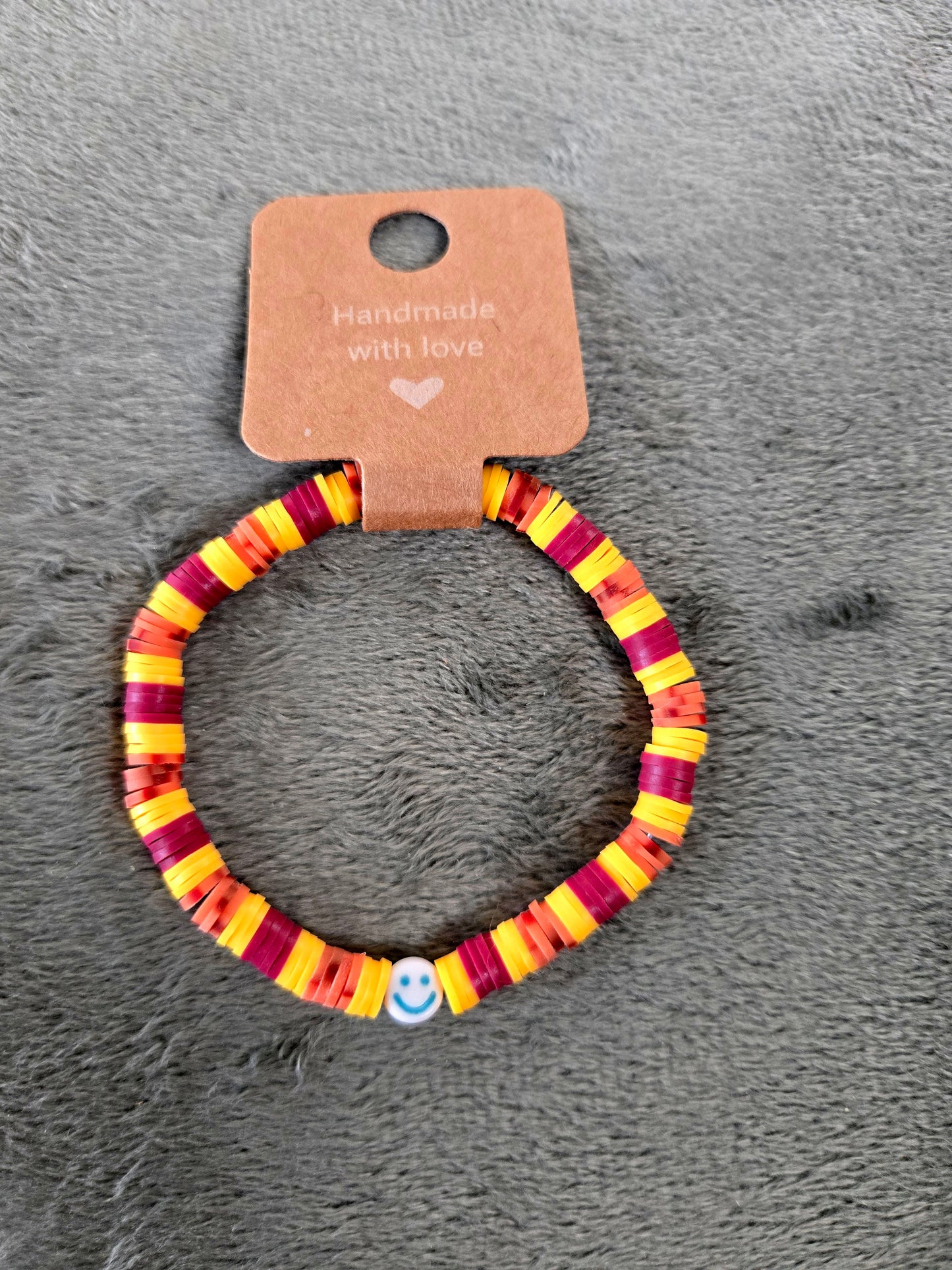 Yellow and burgundy clay beaded bracelet with smiley face