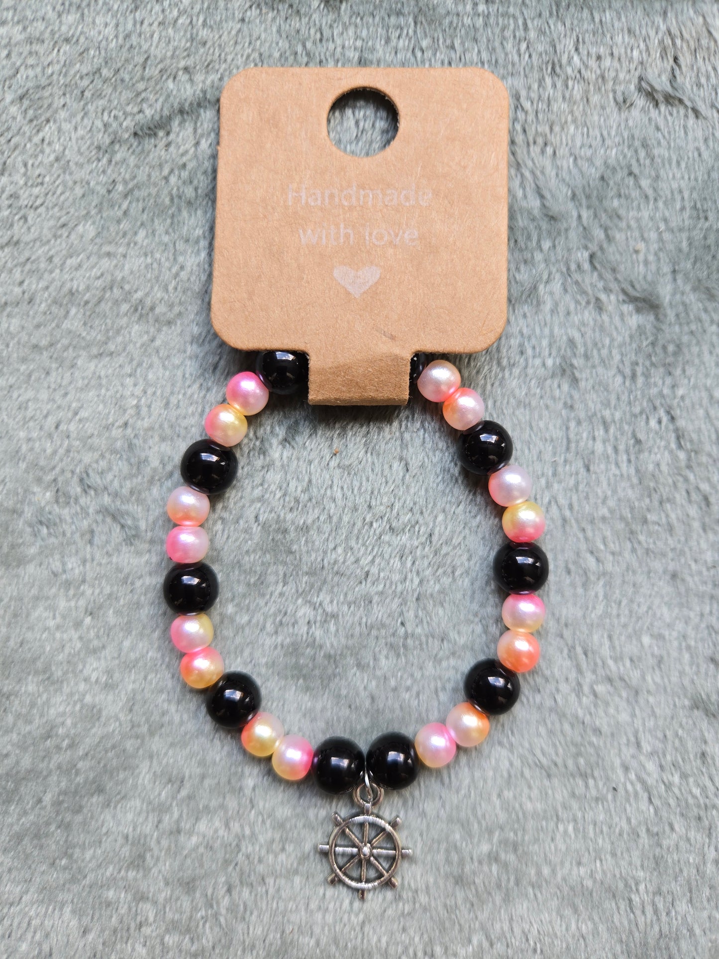 Black and multicolored beaded bracelet with ship's wheel charm