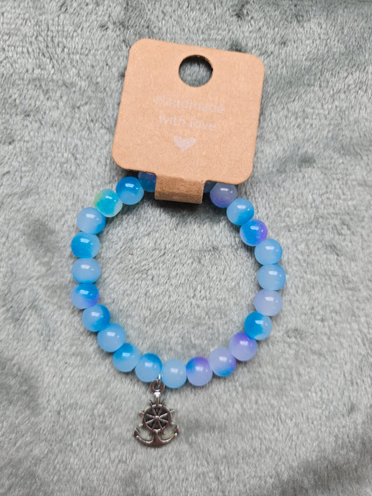 Blue beaded bracelet with silver wheel anchor charm