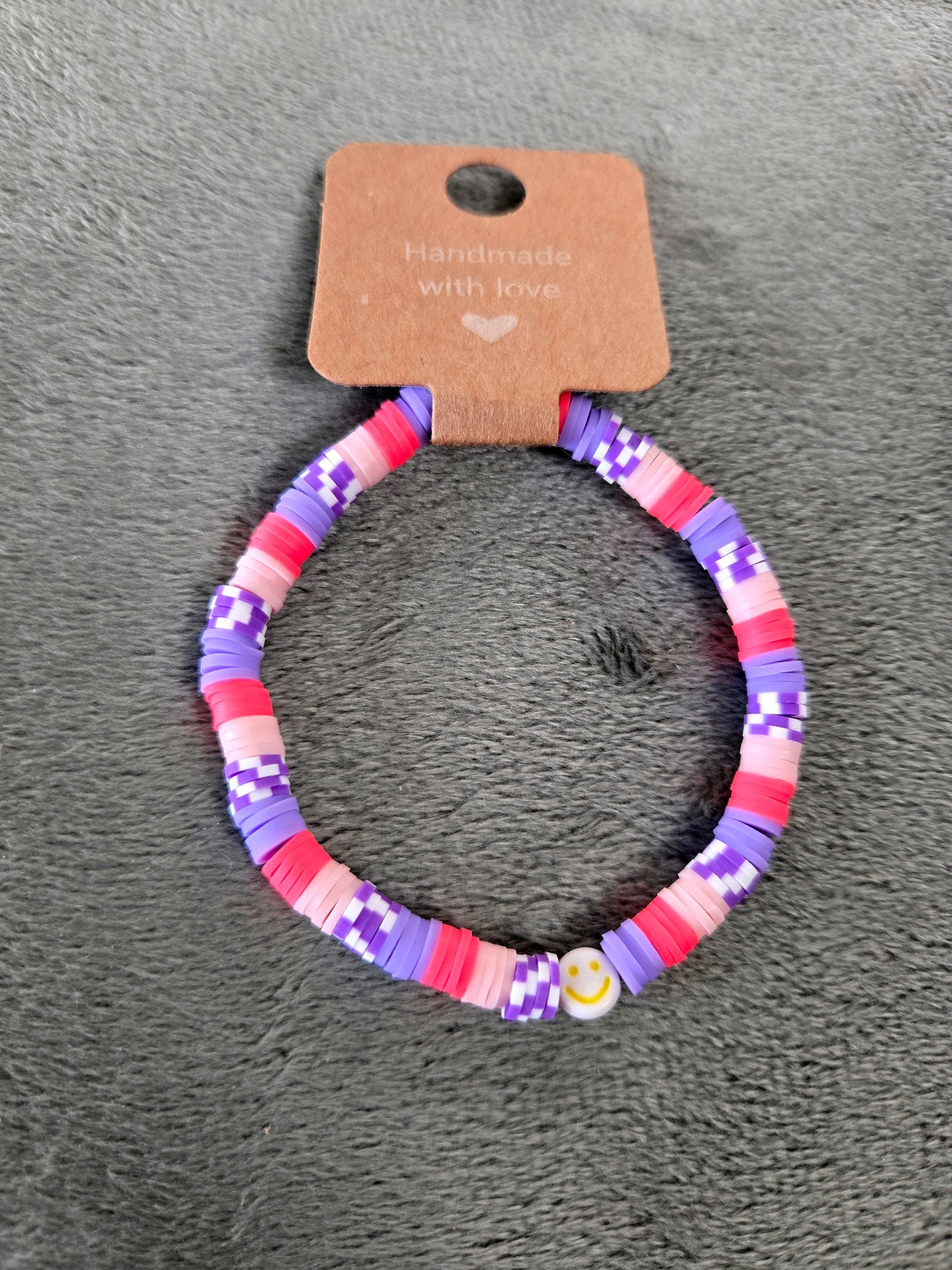 Pink and purple clay beaded bracelet with a smile face