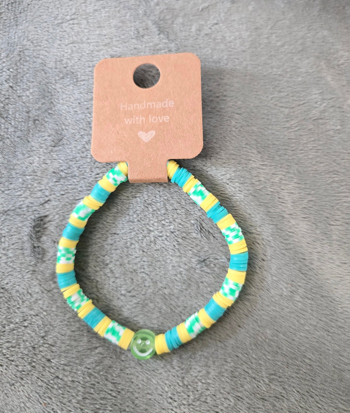 Yellow and green clay beaded bracelet with a smiley face